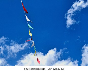Colorful triangular flags on a blue sky background.