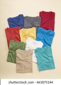 Colorful T-shirts folded group on background