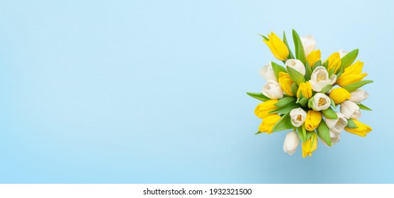 Colorful tulip flowers in front of blue background. With copy space. Top view flat lay - Powered by Shutterstock