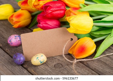 Colorful tulips and Easter candy on a rustic wood surface
