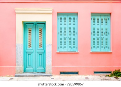 Colorful turquoise blue door and windows in a pink wall.