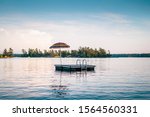 Colorful umbrella on a dock floating out on a beautiful lake, surrounded by nature