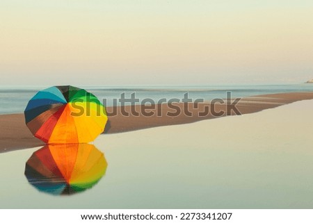 Similar – Colorful striped, closed parasol in close-up on the beach at sunset