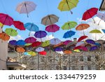 Colorful umbrellas in the blue sky above old street in Carouge town, neighborhood of Geneva, Switzerland, popular tourist traveling destination. 