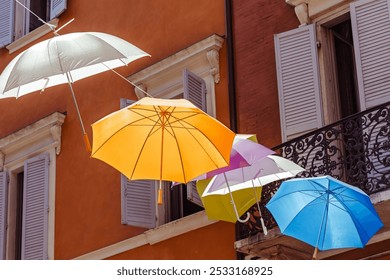 Colorful umbrellas create a vibrant canopy over a charming street in a scenic town of the Modena, Italy, - Powered by Shutterstock