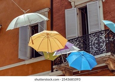 Colorful umbrellas create a vibrant canopy over a charming street in a scenic town of the Modena, Italy, - Powered by Shutterstock