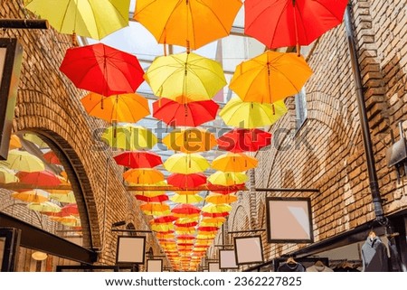 colorful umbrellas hanging from the roof of the Camden Town market