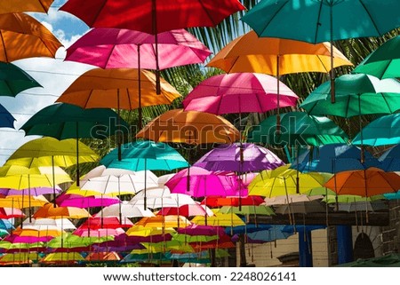 Colorful umbrellas spanning street at Caudan Waterfront shopping center, Port Louis, Mauritius