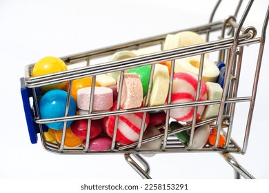 lot of colorful various flavor candies in a small shopping cart. - Shutterstock ID 2258153291