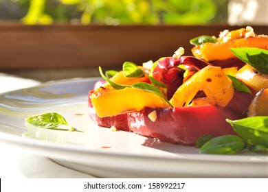 Colorful Vegetables Salad In White Plate Sunlight From Window.Roasted Sweet Peppers,garlic And Fresh Basil Salad. Healthy, Dieting, Veg Food.