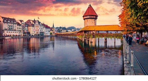 Colorful view of famous old wooden Chapel Bridge (Kapellbrucke), landmark 1300s wooden bridge with grand stone water tower decorated with 17th-century art. Lucerne cityscape, Switzerland.