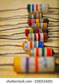 Colorful Vintage Electronic Resistors Lined Up On A Wooden Workbench.