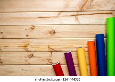 Colorful vinyl rolls on wooden background placed in a row