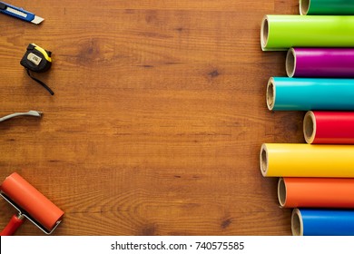 Colorful vinyl rolls on wooden background with your necessary instruments