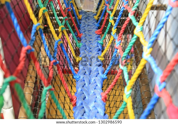 Colorful Walk bridge rope with side rope\
protection on indoor\
playground.