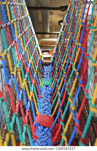 Colorful Walk bridge rope with side rope\
protection on indoor\
playground.