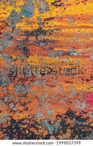 Colorful wall with old paint for the backdrop. Horizontal streams and color mixing. Color - black, yellow, orange. Peeling. Sunset, autumn concept.