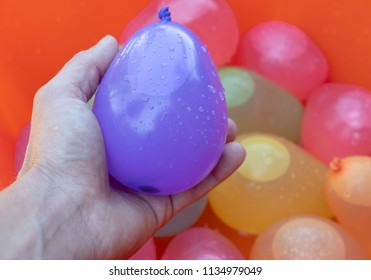 Colorful Water Balloons In Summer For Outside Family Game - Holding Pink Balloon In Hand 