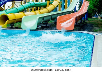 Colorful Waterpark Tubes And Pool In Aquapark. Water Park Slides Close Up. Sunny Summer Day