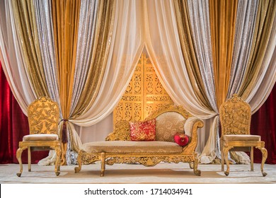 Colorful wedding stage with elegant curtain drawings, seating, and pillows
