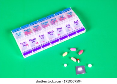 Colorful Weekly Pill Container On Smooth Green Background