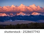 Colorful winter alpenglow over the Colorado Rocky Mountaintops at dawn 