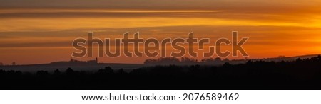 Colorful Wisconsin sunset with silouette of farm in November, panorama
