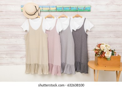 Colorful Womens Clothes On Hangers On Rack On Wood Background.