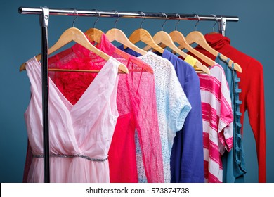 Colorful Womens Clothes On Wood Hangers On Rack On Blue Backgrou