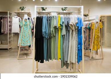 Colorful women's dresses on hangers in a retail shop