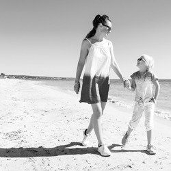 smiling modern mother and daughter on beach walking, a Person Photo by ...