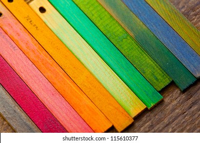 Colorful wood stain color test samples, on rough wood.