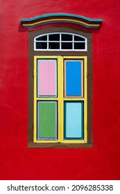 Colorful wooden abstract window on red wall, close up . Colonial style architecture building in Little India , Singapore city . Background and texture of bright architecture