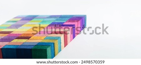 Colorful wooden blocks aligned in a strip on a neutral white background. header, cover mage for something creative or diverse. A Spectrum of multi-colored wooden blocks aligned.