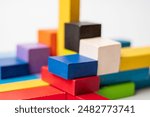 Colorful wooden blocks geometrically arranged forming different shapes, structures, architecture and buildings, isolated on white background