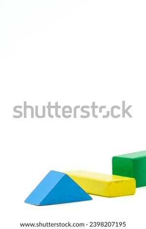 Colorful wooden blocks lying and standing. Cuboid and triangle, in green, yellow and blue blocks isolated on a white background.