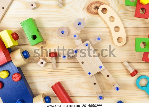 A\
colorful wooden building kit, robot for children on wood. Set of\
tools on wooden table. Games and tools for kids in kindergarten,\
preschool or daycare. Natural, eco-friendly\
toys.