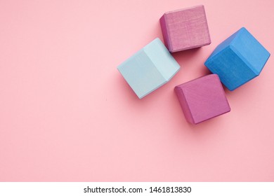 Colorful wooden cubes on pink background.Creativity toys. Children's building blocks.