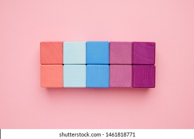 Colorful wooden cubes on pink background top view.Creativity toys. Children's building blocks.