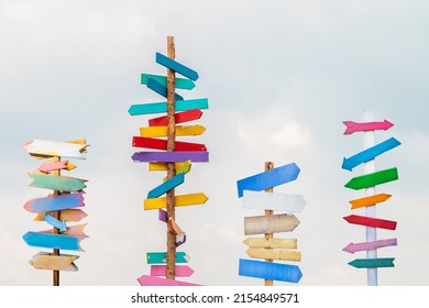 Colorful wooden direction arrow signs on wooden poles - Shutterstock ID 2154849571