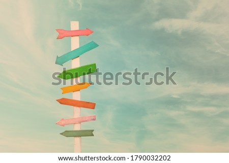 Colorful wooden direction arrow signs on a wooden pole