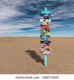 Colorful Wooden Direction Sign With Destination Countries In Empty Desert 