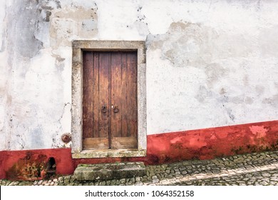 Colorful wooden door in the facade of a typical Portuguese house at Obidos, Portugal.