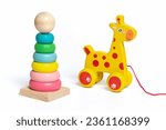 Colorful wooden pyramid, wooden yellow horse on wheels isolated on white background Educational children