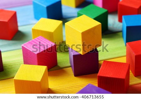 Colorful wooden toy cubes on a colorful wooden background