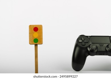 A colorful wooden toy traffic light and a game controller are positioned against a plain white background, emphasizing their bright colors and playful design - Powered by Shutterstock