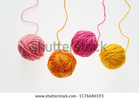 Colorful woolen balls over white background. Balls of wool partially unrolled. 