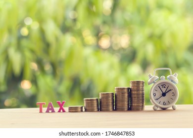 Colorful Word Tax, Alarm Clock ,rows Of Rising Coins On A Table. Concept Tax Collection, Investment And Capital Gain Tax Depicts Financial Charge Levy Imposed Upon A Taxpayer Or Individual