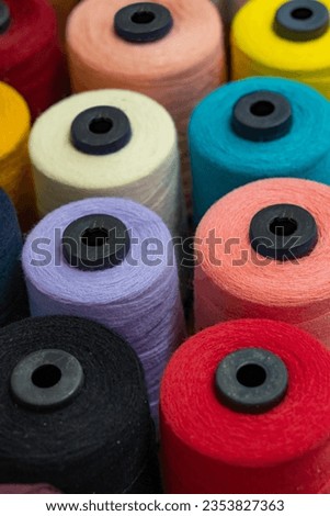 Colorful yarn on spool, tube, cotton, wool, linen thread. Colorful thread spool background, close-up. Multi Colored threads for sewing and needlework
