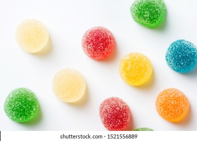 Colorful yellow red orange green gummy jelly candies coated with sugar on white background. Kids birthday party Halloween sweets fun concept. Creative minimalist food poster top view. Blurry - Powered by Shutterstock